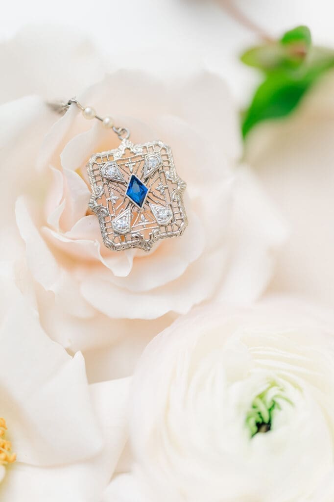 A macro photo of an heirloom necklace with a blue sapphire in the center. 