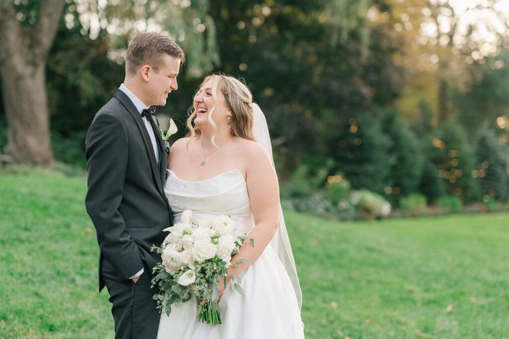 Trey and Magdalene smile widely at one another at their woodwinds wedding