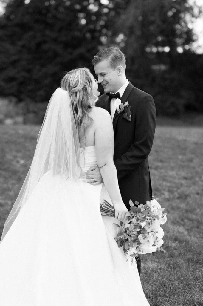 Trey and Magdalene nuzzle noses at their woodwinds wedding