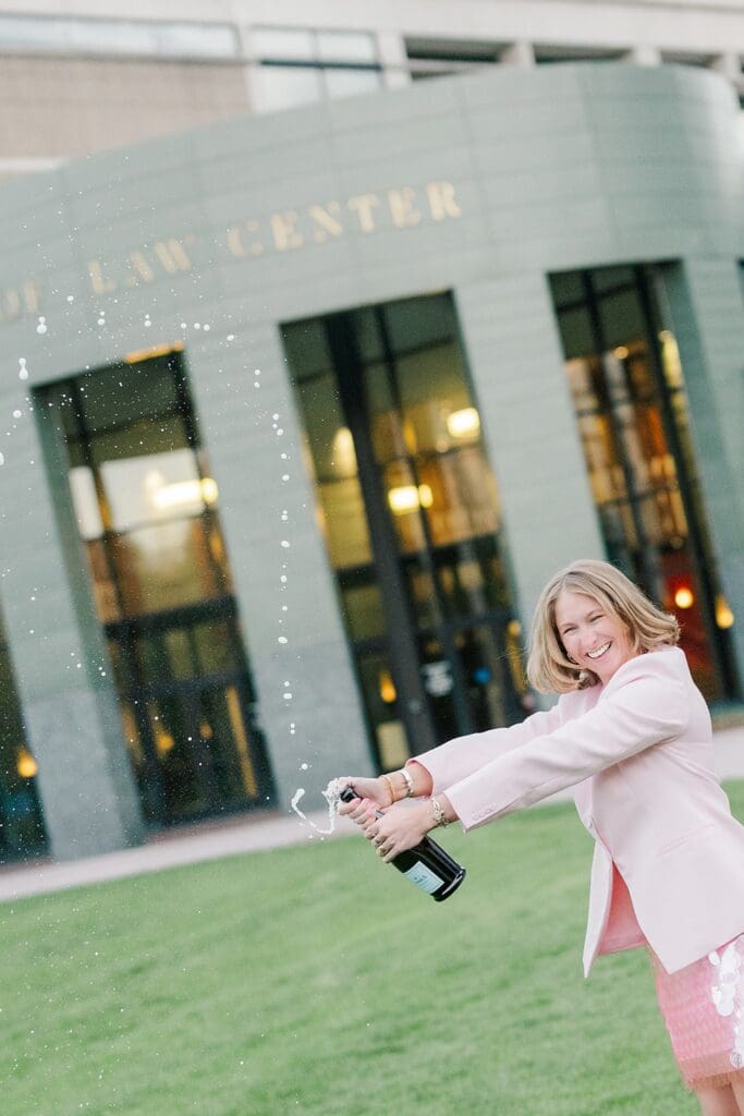 Abby pops a bottle of champagne at Quinnipiac Law School. 