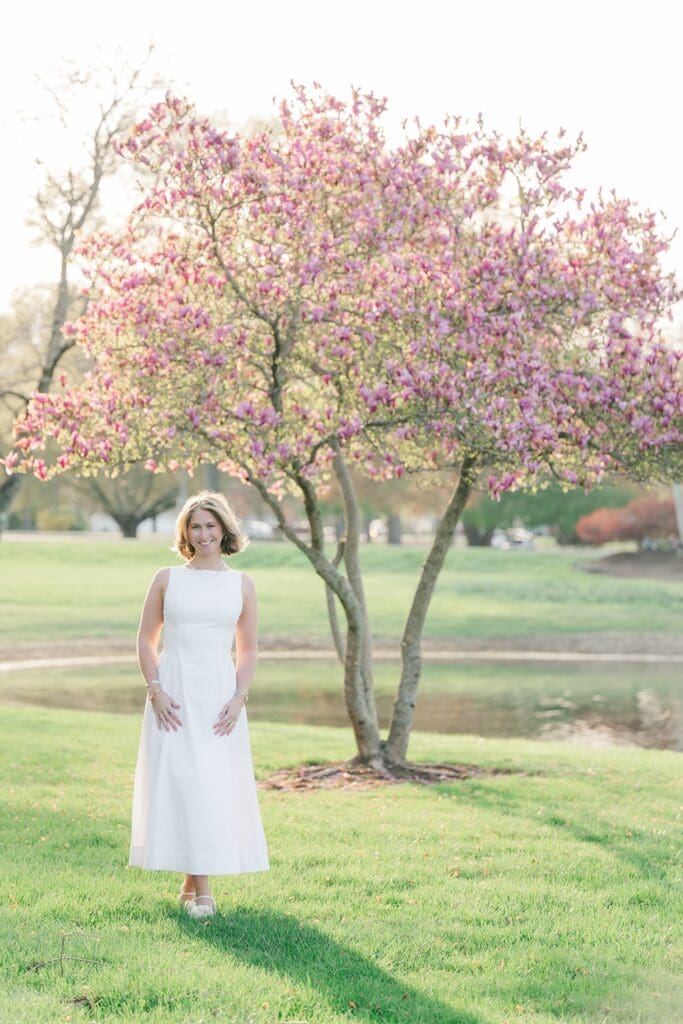 Abby smiles underneath a blooming tree at Quinnipiac Law School. 