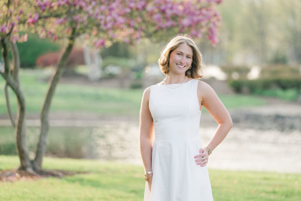 Abby smiles next to a blooming tree at Quinnipiac Law School. 