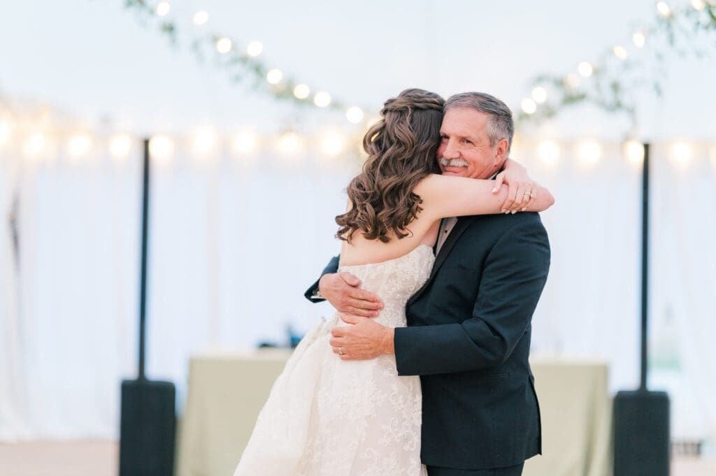 Miranda hugs her dad as they dance together. 