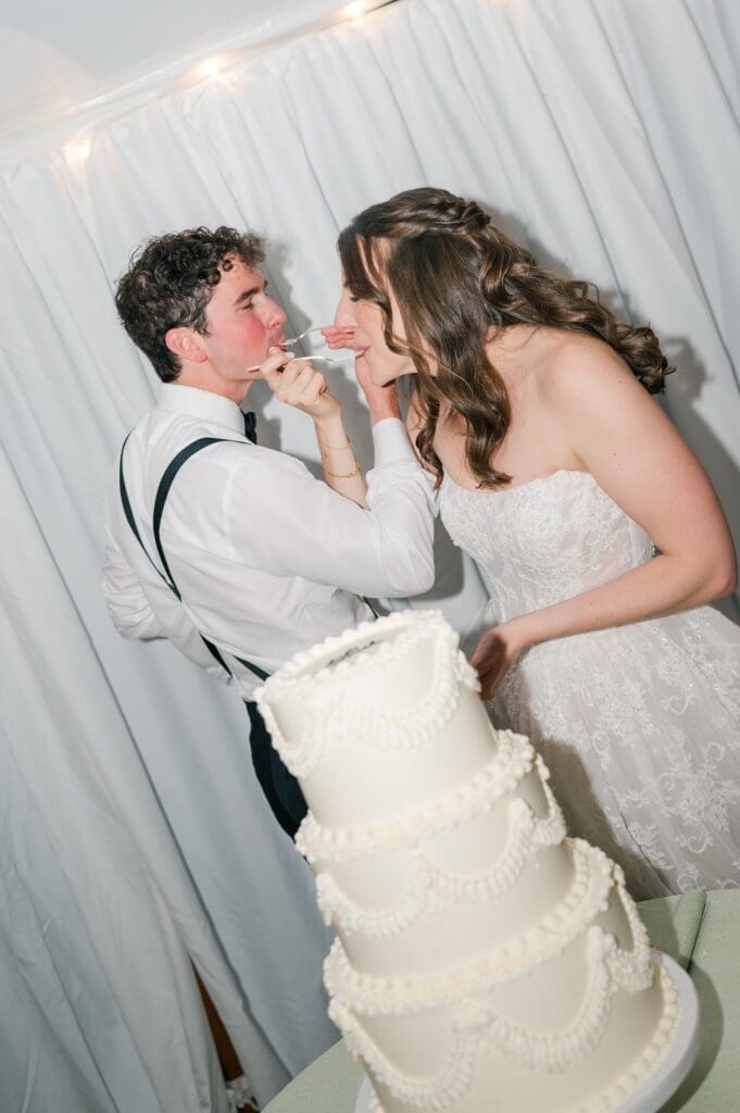 Miranda and Mitch standing behind a three tier wedding cake. 