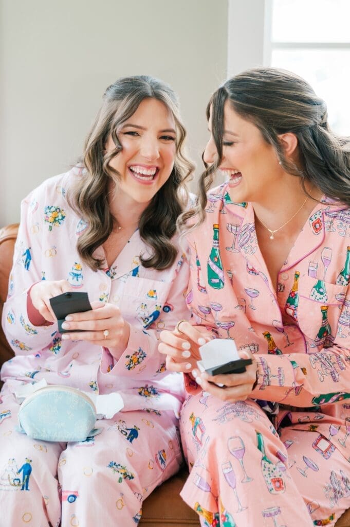 The bride and her sister smile as they open up gifts with one another. 