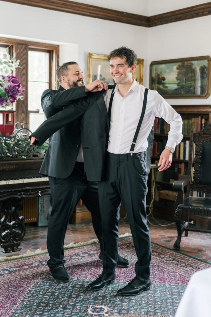 Mitch putting on his suit jacket in the library at Aldworth Manor for his wedding. 