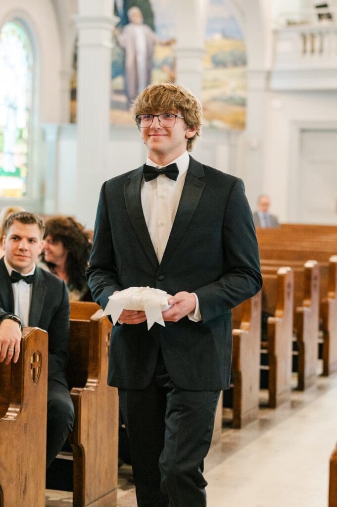 The ring bearer walks down the aisle. 