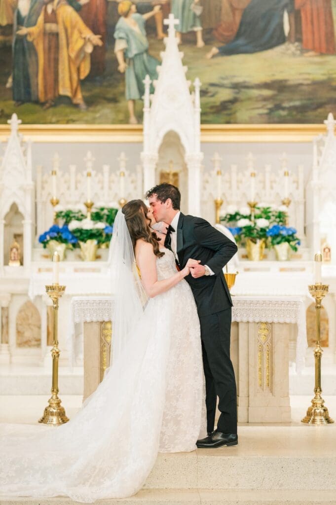 The bride and groom share their first kiss in the Catholic church. 