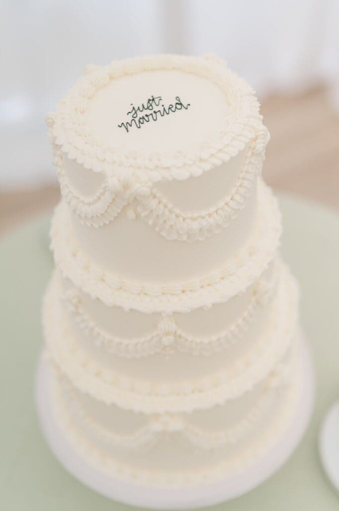 A three-tier vintage piped wedding cake that says "just married" across the top. 