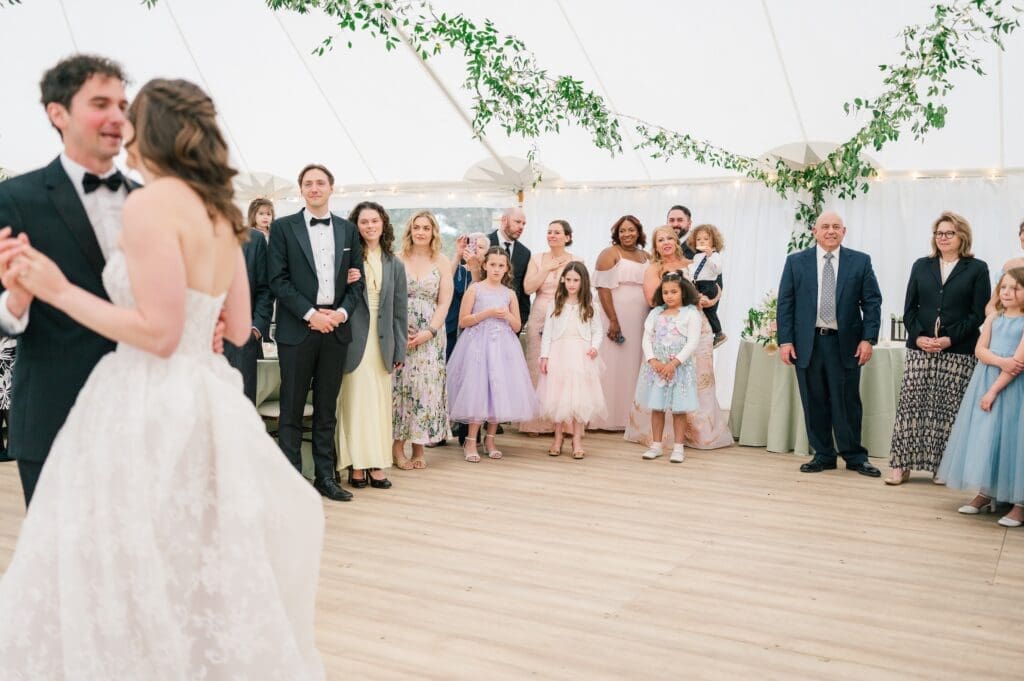 The bride and groom's guests watch as they do their first dance at their Aldworth Manor Wedding. 