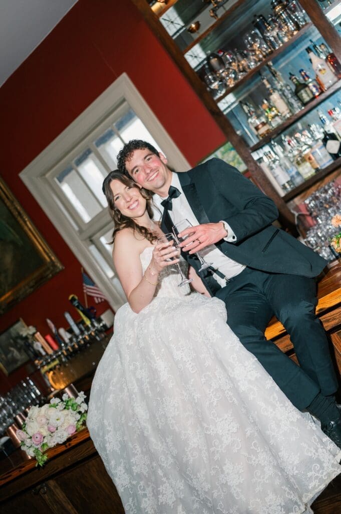 Mitch and Miranda cheers glasses in the bar at Aldworth Manor. 