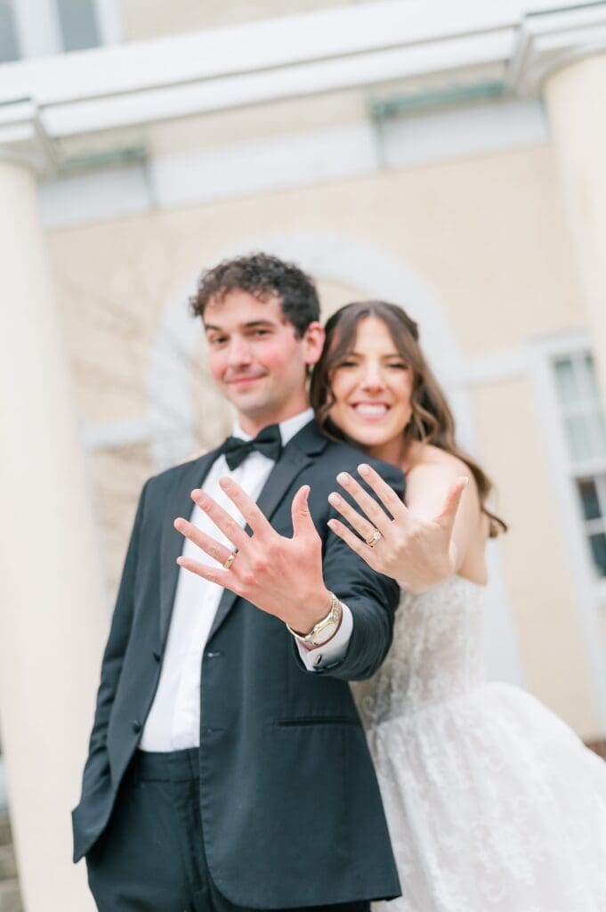 Mitch and Miranda hold up their wedding rings. 
