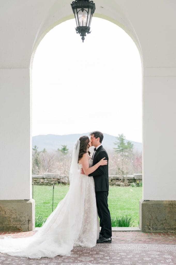Miranda and Mitch kiss in front of the mountain at Aldworth Manor for a wedding portrait. 
