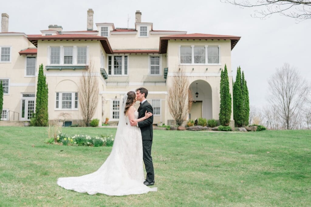 Miranda and Mitch kiss outside of Aldworth Manor for a wedding portrait. 
