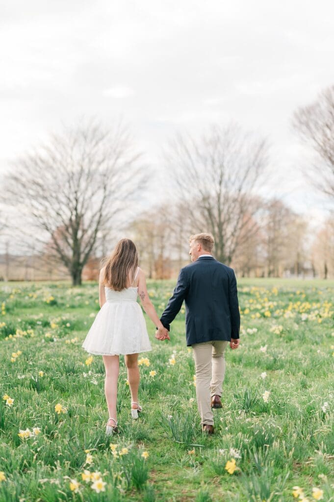 Syd and Dylan hold hands and walk along the daffodils at Harkness Memorial State Park. 