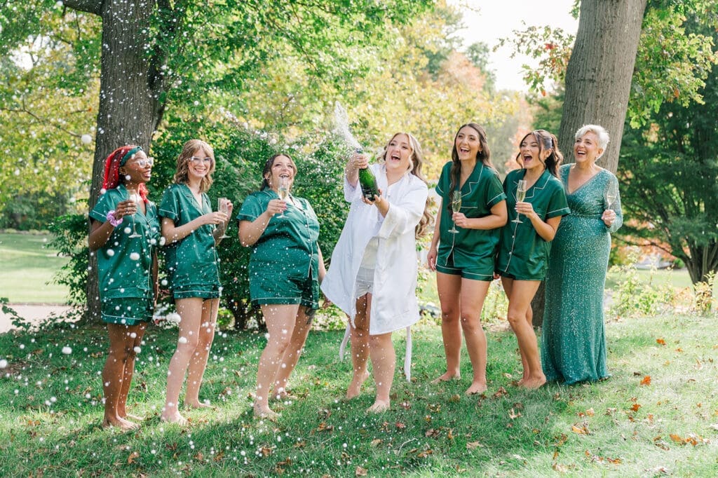 Magdalene popping champagne with her bridesmaids and her mom. 
