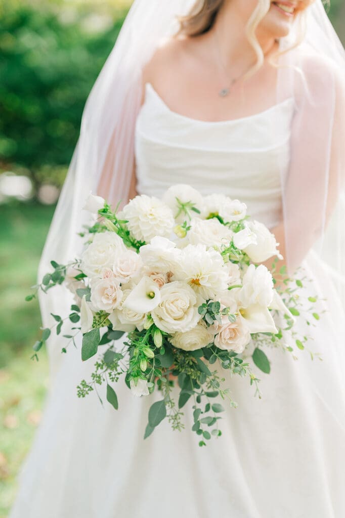 A close-up of a bridal bouquet with white florals. 