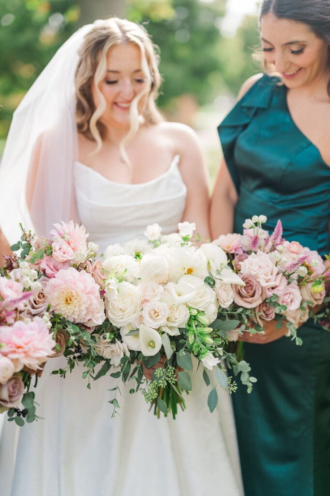 Magdalene and her bridesmaids hold their bouquets next to one another. 