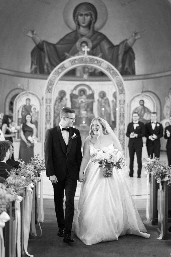 Trey and Magdalene celebrate being newlyweds as the walk down the aisle together. 