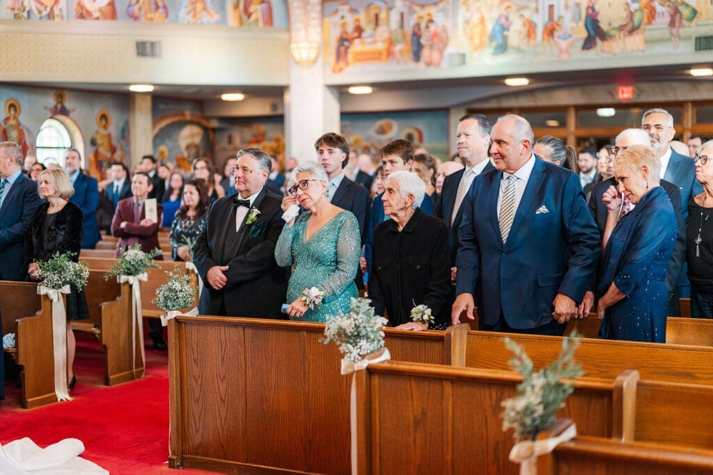 Magdalene's mom wipes her eyes as her daughter is on the altar to get married. 