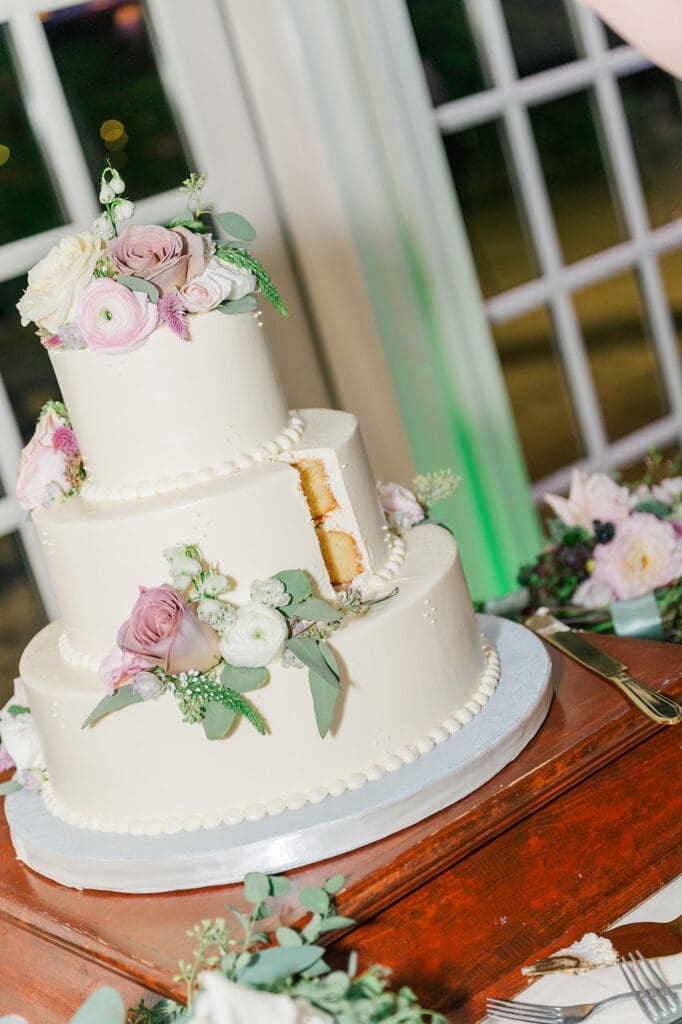 The wedding cake with a slice cut out of it. 