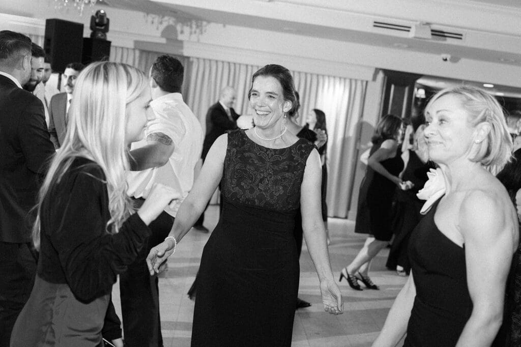 Trey's mom smiles and dances with friends on the dance floor at Woodwinds 