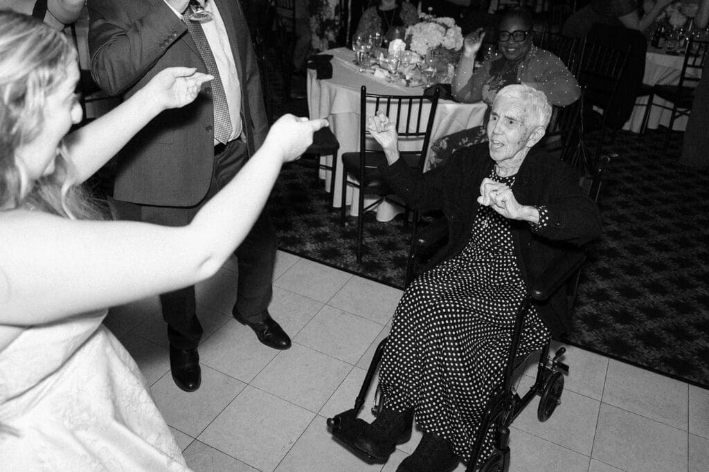 Grandma in a wheelchair dances on the dancefloor