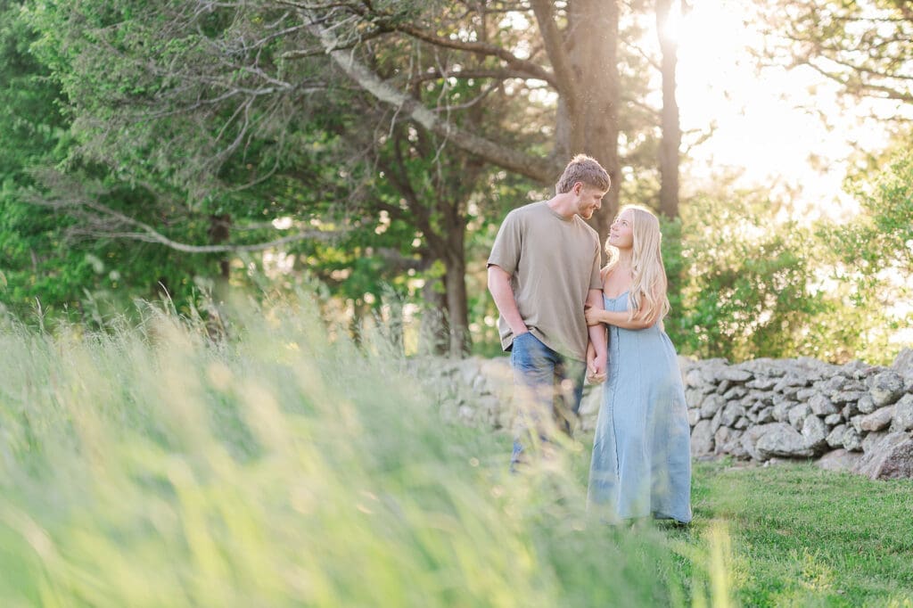 A woman walking with her fiance at Topsmead State Park for their engagement photos