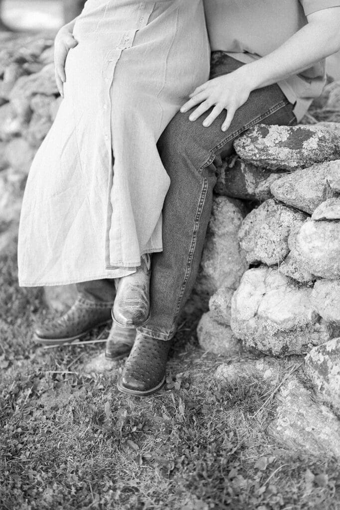A woman sitting on a man's lap wearing cowboy and cowgirl boots