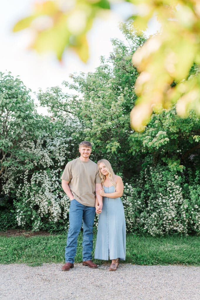 A woman and man smile at Topsmead State Park for their engagement photos