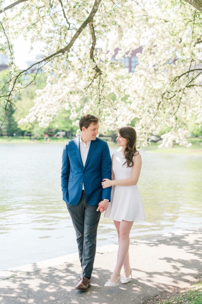 Julia and Brandon smile at one another during their spring boston public garden engagement photos