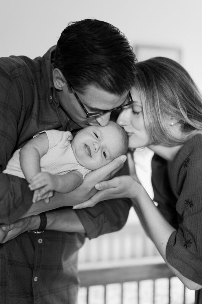 Mom and Dad hold Baby G and kiss his head