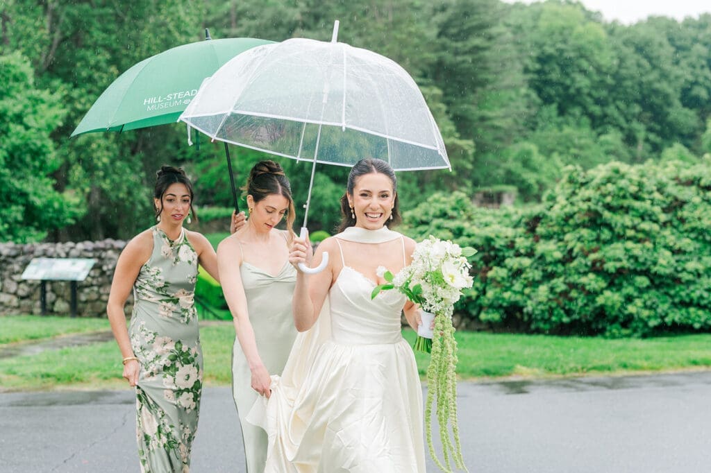 Natalie walks with a clear umbrella on her rainy wedding day at Hill-Stead Museum.