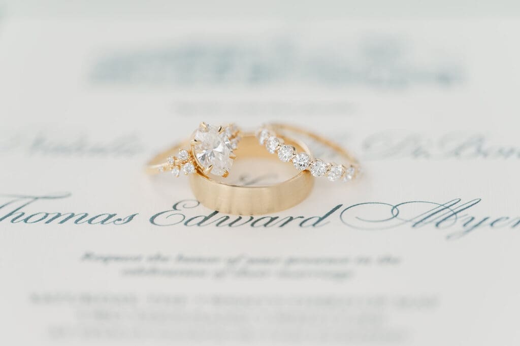 A macro shot of Natalie and Toms' rings on their invitation suite.