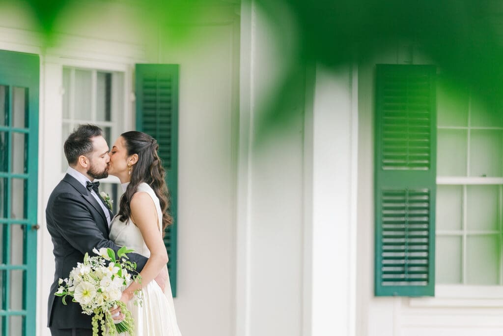 Tom and Natalie kiss on the front porch of Hill-Stead Museum. 