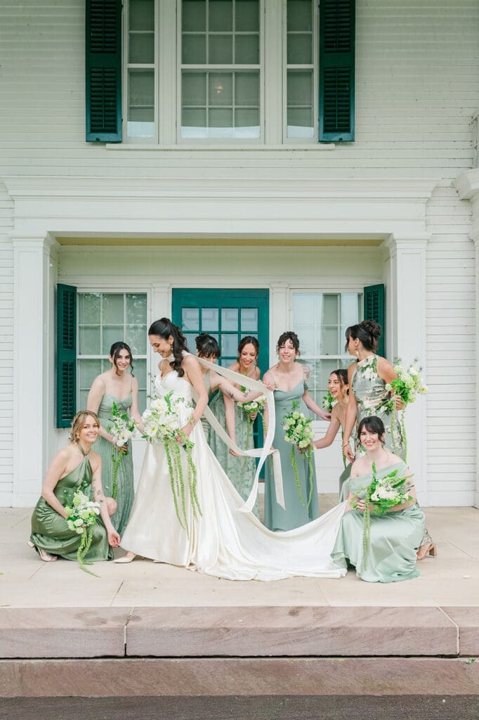 Natalie stands as her bridesmaids fix her dress around her