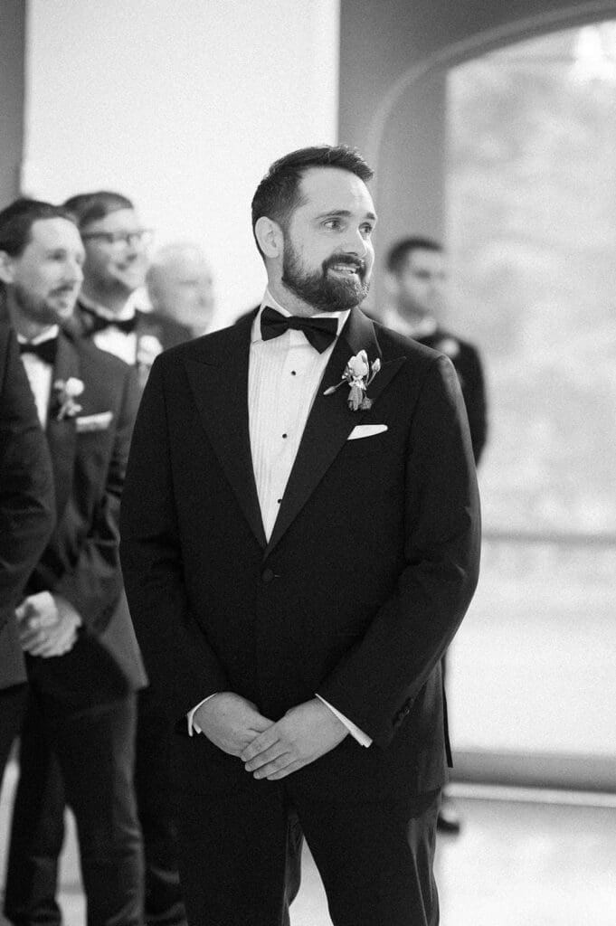 Tom smiles as Natalie walks down the aisle. 