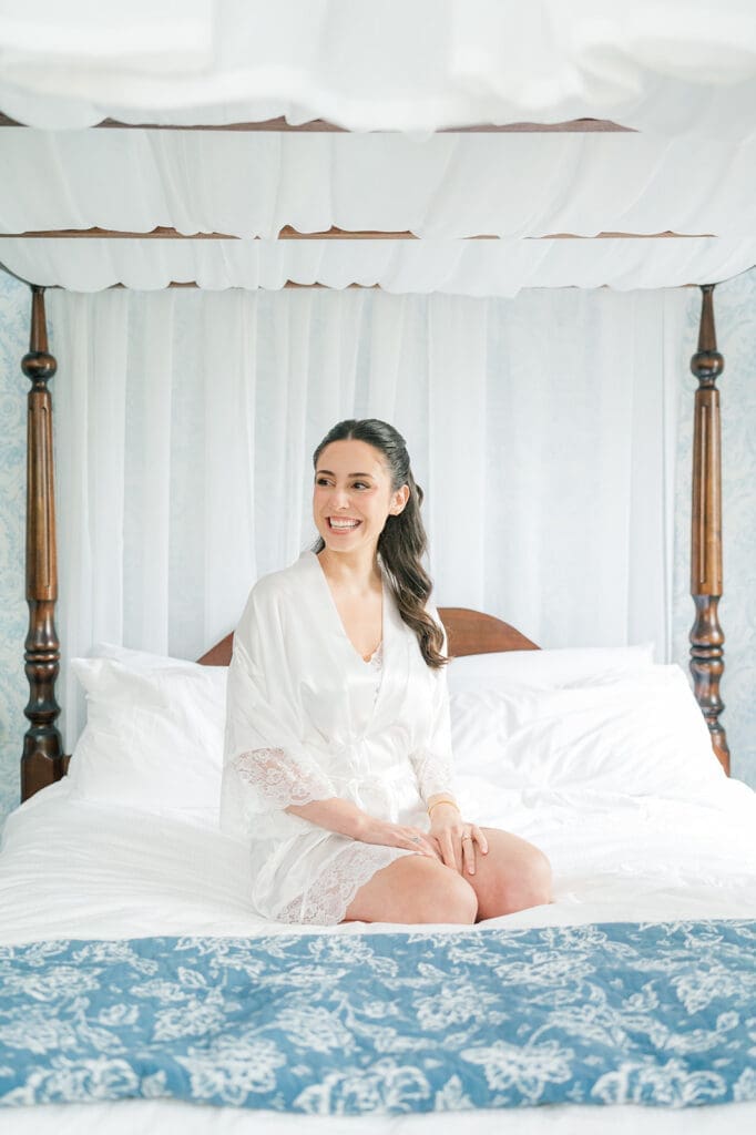 A bride sitting on her bed at at the Simsbury 1820 Inn. 
