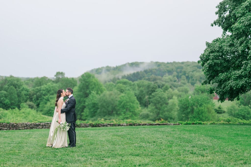 Natalie and Tom kiss at Hill-Stead on their rainy wedding day. 