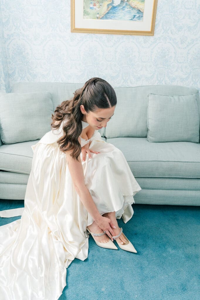Natalie leans over and puts on her Jimmy Choo heels at the Simsbury 1820 Inn. 