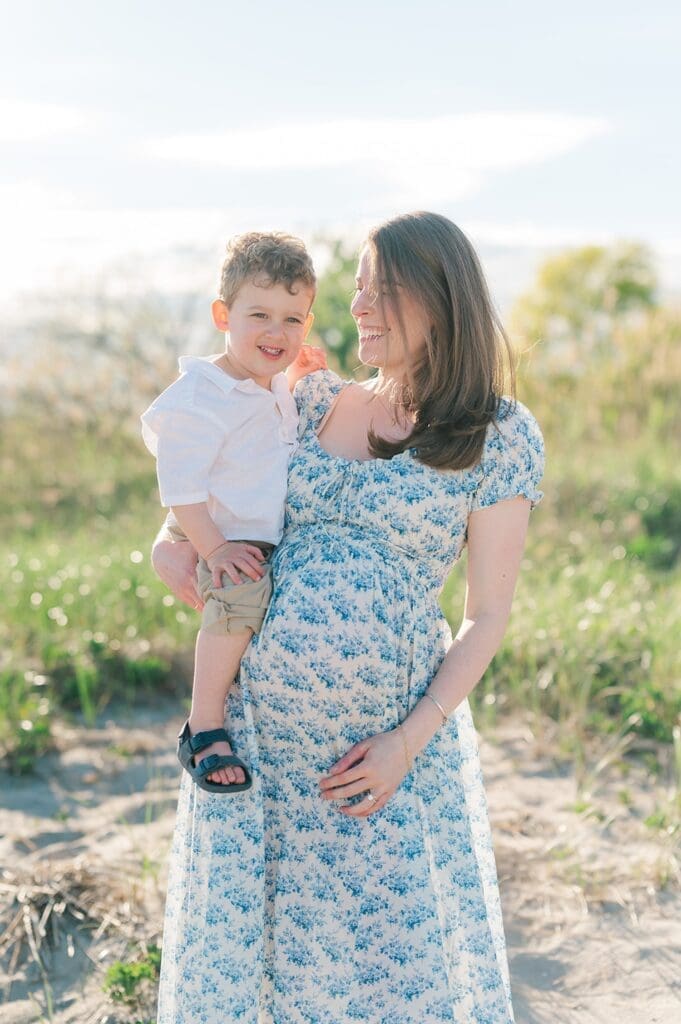 A woman holds her toddler son on her hip at Sherwood Island State Park. 
