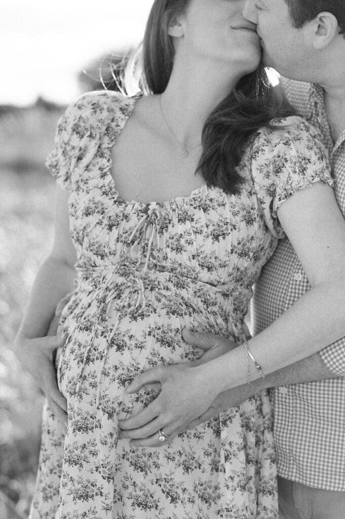 A woman caresses her belly at Sherwood Island State Park. 
