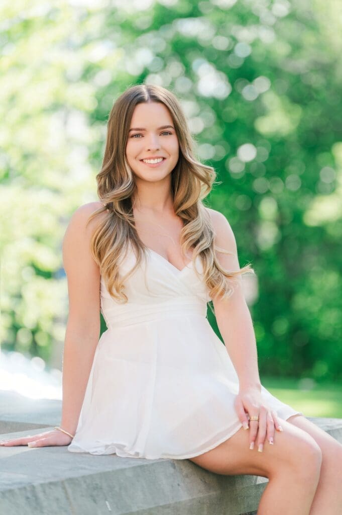 Sophia sits on a ledge and smiles