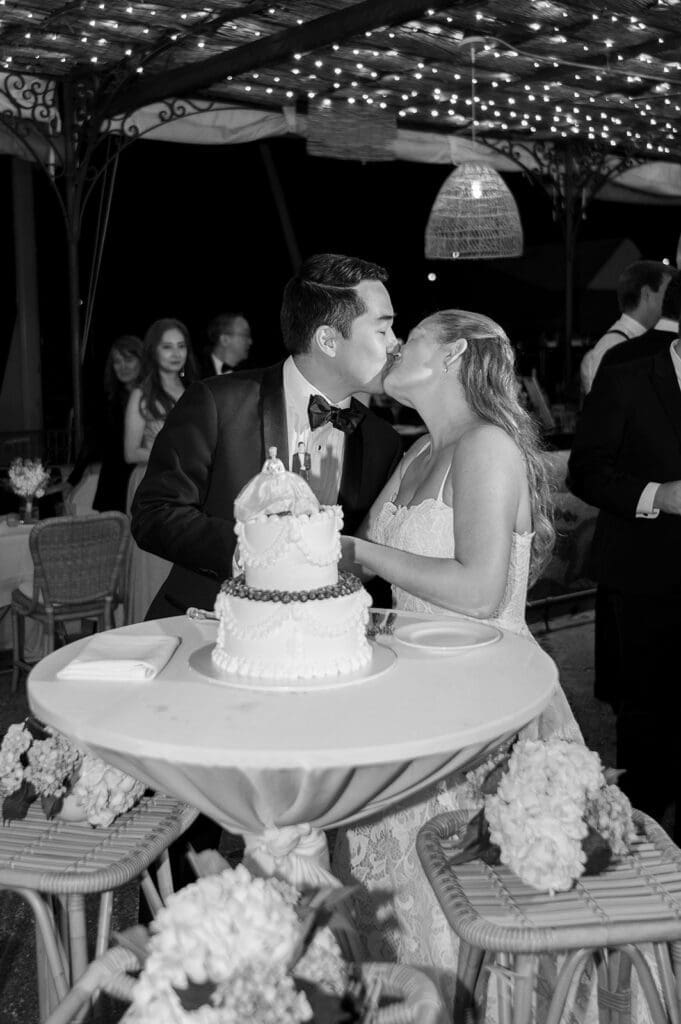 Katie and Sang kiss while cutting their cake at their Delamar Greenwich Wedding. 