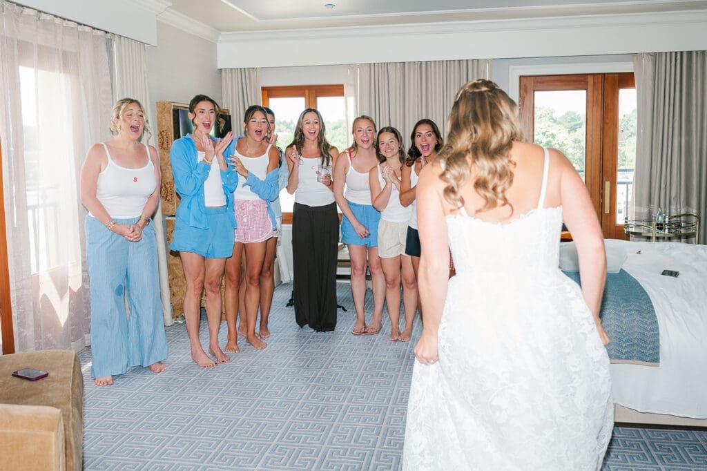 Katie does a dress reveal with her bridesmaids as they smile in excitement