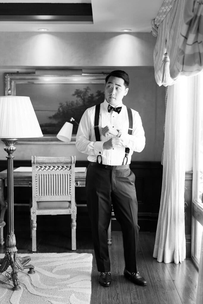 Sang puts on his cufflinks and looks off into the distance