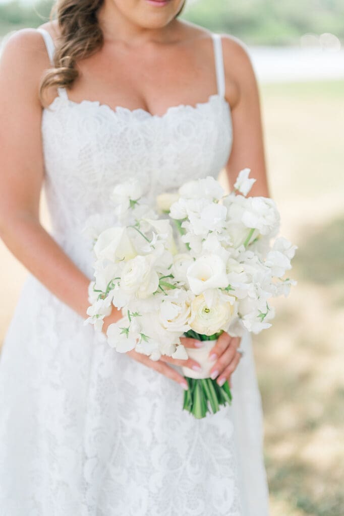Katie holds a bouquet of white florals. 