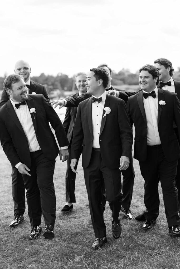 Sang and his groomsmen laugh together while they walk 