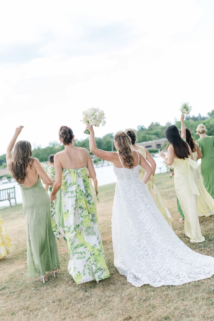 Katie and her bridesmaids hold up their bouquets as they walk together. 