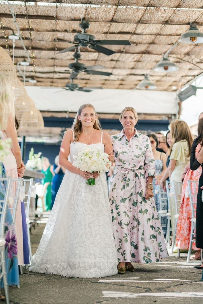 Katie walks down the aisle with her mom. 